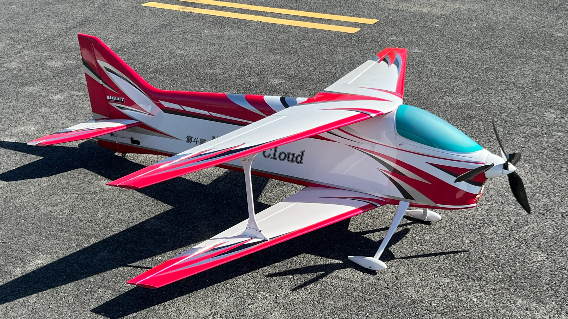 Red and white BJCRAFT Muscle Cloud aerobatic model aircraft on a runway